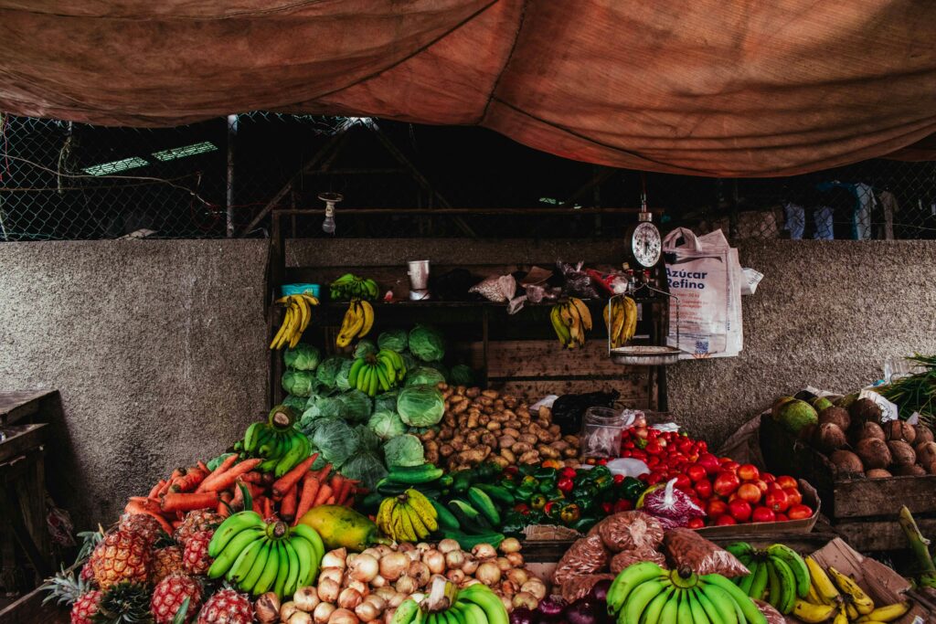Colorful array of fruits and vegetables at a market stall with rustic ambiance.
