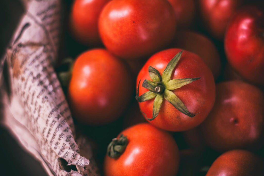 Close-up image of ripe, juicy cherry tomatoes arranged on a page of newspaper.