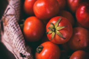 Close-up image of ripe, juicy cherry tomatoes arranged on a page of newspaper.